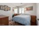 This carpeted bedroom has a bright window, full-length mirror, and overhead lighting at 13864 W Ironwood St, Surprise, AZ 85374