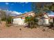 Beige single story home with a red clay roof sitting on a desert landscape under bright blue skies with scattered clouds at 13864 W Ironwood St, Surprise, AZ 85374