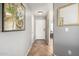 Inviting hallway with neutral paint, tile flooring, and decorative art leading into the rest of the home at 13864 W Ironwood St, Surprise, AZ 85374