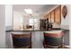 Kitchen with dark countertops, tile backsplash, stainless steel appliances, and a breakfast bar with barstool seating at 13864 W Ironwood St, Surprise, AZ 85374