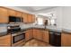 Spacious kitchen features wood cabinets, granite countertops, and stainless steel appliances at 13864 W Ironwood St, Surprise, AZ 85374