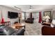 Well-lit living room with leather furniture, plush carpet, and sliding glass doors to the outdoor space at 13864 W Ironwood St, Surprise, AZ 85374