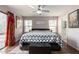 Bright and spacious main bedroom with a ceiling fan, backyard access, and an ensuite bathroom at 13864 W Ironwood St, Surprise, AZ 85374