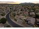 An aerial view shows a well-maintained community with homes, desert landscaping, and many with solar panels at 14621 W Catalina Dr, Goodyear, AZ 85395