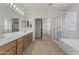 Spacious bathroom features a walk-in shower, garden tub, and double sinks with wood cabinets at 14621 W Catalina Dr, Goodyear, AZ 85395