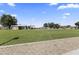 A view of the community park featuring lush green grass, mature shade trees, and recreational facilities at 14621 W Catalina Dr, Goodyear, AZ 85395