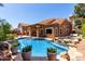 Beautiful backyard pool and spa with rock features, surrounded by lush greenery and a tile roof home at 1521 W Kent Dr, Chandler, AZ 85224
