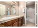Well-lit bathroom featuring double sinks, wood cabinets and shower with tub at 1521 W Kent Dr, Chandler, AZ 85224