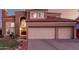 The exterior of a two-story home featuring a red tile roof, arched entry, and three-car garage at 1521 W Kent Dr, Chandler, AZ 85224