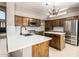 A kitchen showcases knotty wood cabinets, stainless appliances, white countertops, and an island at 1521 W Kent Dr, Chandler, AZ 85224