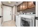 Convenient laundry room with modern washer and dryer units and functional upper cabinets at 1521 W Kent Dr, Chandler, AZ 85224