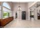 Spacious living area with a buffet, chandelier, and an arched window, complemented by tiled floors at 1521 W Kent Dr, Chandler, AZ 85224