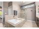 Relaxing main bathroom with soaking tub, glass-enclosed shower, and neutral tile at 1521 W Kent Dr, Chandler, AZ 85224