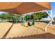 Community playground swing set area with colorful swing set surrounded by protective mulch at 1521 W Kent Dr, Chandler, AZ 85224