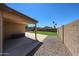 Large backyard with neutral colored walls, a stone area, and a well maintained lawn at 15537 W Port Royale Ln, Surprise, AZ 85379