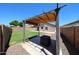 Cozy backyard featuring a pergola, lush green lawn, and a well-maintained rock garden at 15537 W Port Royale Ln, Surprise, AZ 85379