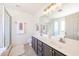 Bright bathroom featuring dual sinks, a walk-in shower, and modern fixtures for a functional and stylish design at 15537 W Port Royale Ln, Surprise, AZ 85379