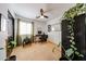 Bedroom space set up as an office featuring neutral carpet and a ceiling fan and several plants at 15537 W Port Royale Ln, Surprise, AZ 85379