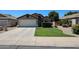 Charming single-story home featuring a well-maintained front yard with lush green grass and manicured landscaping at 15537 W Port Royale Ln, Surprise, AZ 85379