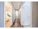 Hallway featuring wood floors with bathroom and a laundry room, both offering plenty of natural light at 15537 W Port Royale Ln, Surprise, AZ 85379