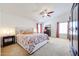 Serene main bedroom featuring a ceiling fan, plush carpet, ample natural light, and comfortable furnishings at 15537 W Port Royale Ln, Surprise, AZ 85379