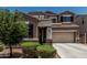 Inviting two-story home showcasing a spacious two-car garage and front yard landscape with shrubs under a clear, blue sky at 1723 N Hillcrest --, Mesa, AZ 85201