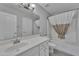 Well-lit bathroom featuring a single sink vanity, a combined tub and shower, and neutral tile floors at 18088 W San Alejandro Dr, Goodyear, AZ 85338