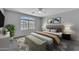 Cozy bedroom featuring a large window, stylish decor, and gray carpeted floors with a ceiling fan at 18088 W San Alejandro Dr, Goodyear, AZ 85338