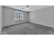 Spacious bedroom with a large window and gray carpeted floor. Ready for your personal touch at 18088 W San Alejandro Dr, Goodyear, AZ 85338