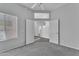 Spacious bedroom with double doors and a window that fills the space with natural light and gray carpeted floor at 18088 W San Alejandro Dr, Goodyear, AZ 85338