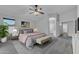 Staged main bedroom with carpet, ceiling fan, and light neutral paint at 18088 W San Alejandro Dr, Goodyear, AZ 85338