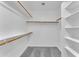 Organized walk-in closet with multiple shelves and rods for ample storage and gray carpeted floor at 18088 W San Alejandro Dr, Goodyear, AZ 85338
