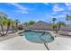 A private backyard pool surrounded by desert landscaping, lounge chairs, palm trees, and blue skies at 18088 W San Alejandro Dr, Goodyear, AZ 85338