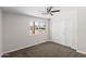 Bedroom features a ceiling fan, closet, fresh paint, and a window with outdoor view at 1911 E Lawrence Rd, Phoenix, AZ 85016