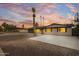 Charming home boasts desert landscaping, complemented by palm trees and a newly sealed driveway at 1911 E Lawrence Rd, Phoenix, AZ 85016