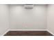 An Empty room is shown with a ceiling mounted mini-split AC unit, white walls, and dark wood flooring at 1911 E Lawrence Rd, Phoenix, AZ 85016