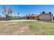 Spacious backyard with a covered patio, mature trees, block fencing and a large grassy area at 1930 W Voltaire Ave, Phoenix, AZ 85029