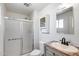 Bright bathroom with white walls, sliding shower doors, vanity, mirror, and toilet at 1930 W Voltaire Ave, Phoenix, AZ 85029