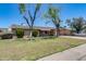 Charming single-story home featuring mature trees, a covered front porch, and a well-manicured lawn at 1930 W Voltaire Ave, Phoenix, AZ 85029