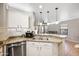 Kitchen with stainless steel dishwasher, granite countertops, and eat-in bar overlooking living room at 2006 W Gold Dust Ave, Queen Creek, AZ 85144