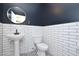 Stylish half-bathroom with a pedestal sink, subway tile walls, modern mirror, and patterned tile floor at 20258 S 196Th St, Queen Creek, AZ 85142