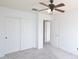Bright bedroom with neutral paint and plush carpeting includes a ceiling fan and closet with sliding doors at 20258 S 196Th St, Queen Creek, AZ 85142
