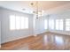Open living room with hardwood floors, large windows with plantation shutters, and a contemporary light fixture at 20258 S 196Th St, Queen Creek, AZ 85142
