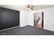 Spacious living room with a modern black accent wall, plush carpet, and an entryway to the staircase at 20258 S 196Th St, Queen Creek, AZ 85142