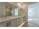 Bright bathroom features double sink vanity, large mirrors and wood look tile flooring at 21411 W Meadowbrook Ave, Buckeye, AZ 85396