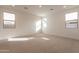 Spacious bedroom with neutral carpet and an abundance of natural light from multiple windows at 21411 W Meadowbrook Ave, Buckeye, AZ 85396