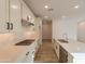Modern kitchen featuring white cabinets, quartz countertop island with seating, stainless appliances and wood-style tile flooring at 21411 W Meadowbrook Ave, Buckeye, AZ 85396