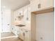 Charming kitchen features white cabinets, quartz countertops, stainless steel appliances, and wood-style tile flooring at 21411 W Meadowbrook Ave, Buckeye, AZ 85396