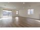 Unfurnished living space with wood-look tile flooring, recessed lighting, and large sliding glass door at 21411 W Meadowbrook Ave, Buckeye, AZ 85396