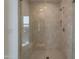 Shower featuring neutral tile, a built-in bench, and a clear glass surround at 21411 W Meadowbrook Ave, Buckeye, AZ 85396